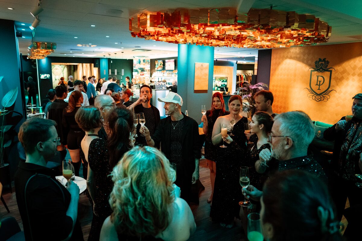 Volle Bar im DANCEIMPERIAL Regensburg: Gäste stoßen mit Sektgläsern an, im Hintergrund die beleuchtete Theke