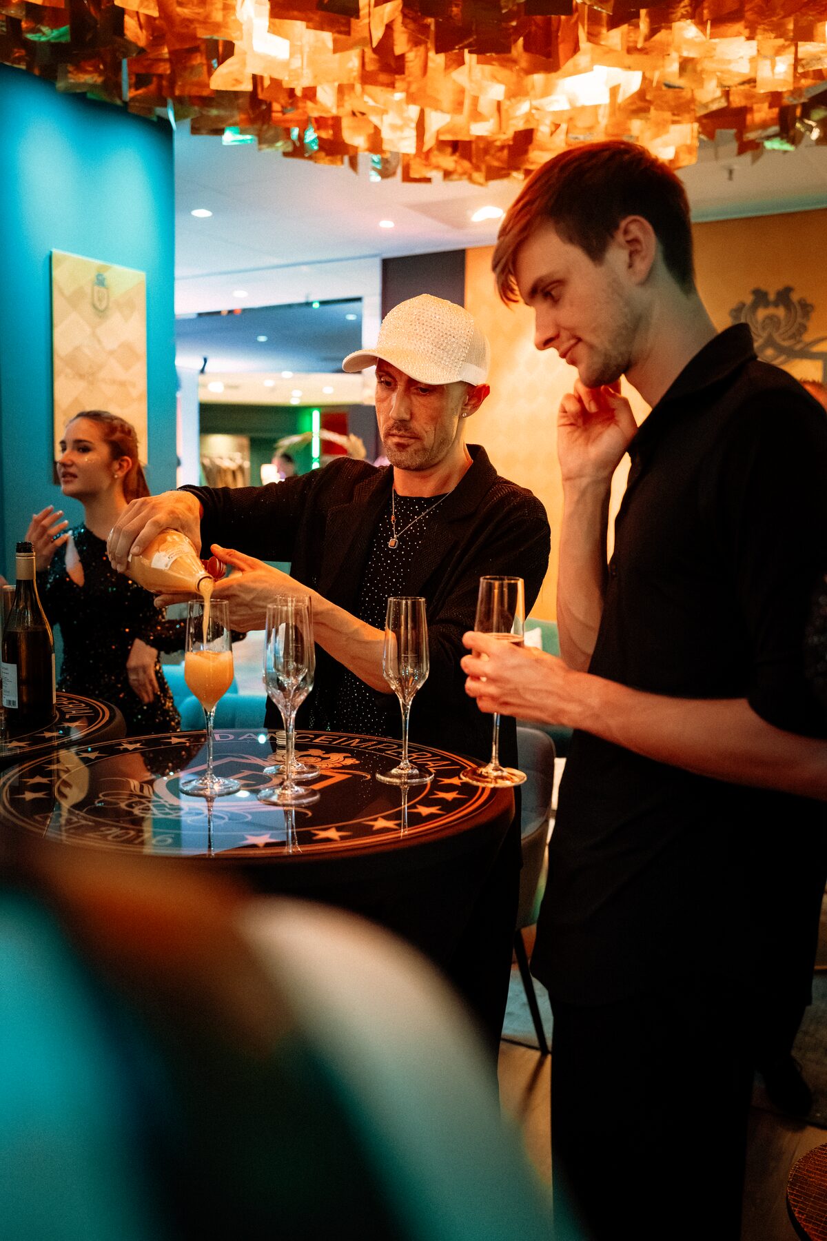 Am Stehtisch der Bar im DANCEIMPERIAL wird Sekt in Gläser eingeschenkt